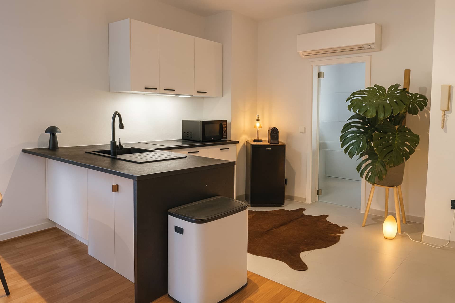 Kitchen with black worktop and microwave